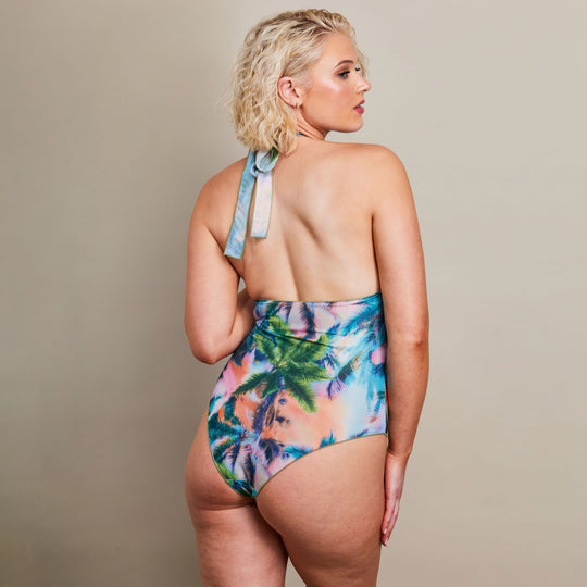 Girl in blue halterneck swimsuit from the back